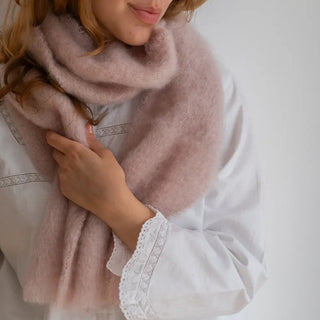 Mujer abrigada con un foulard de mohair, una fibra de origen natural ultra cálida y ligera, de gran calidad. Real Fábrica. 