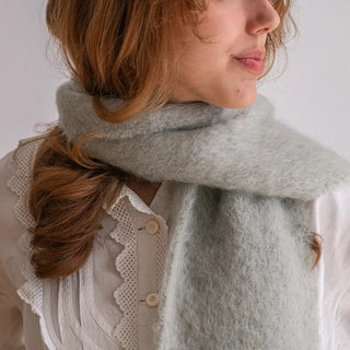 Modelo abrigada con un foulard de mohair en color verde claro, cálido, suave y esponjoso. Real Fábrica.