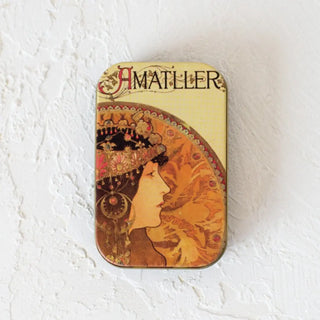 Foto de una lata de hojas de chocolate cerrada sobre una superficie blanca. Real Fábrica.