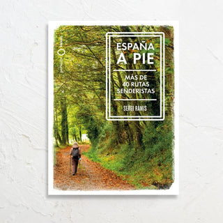 Portada del libro España a Pie con fondo de un bosque y una senderista caminando por un sendero. Real Fábrica