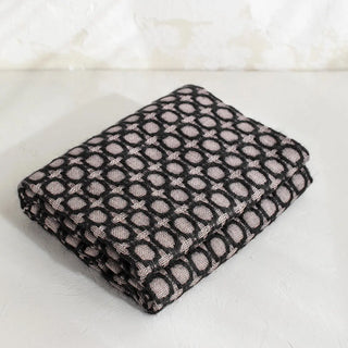 La manta riojana, elaborada a mano con una mezcla de mohair y lana, destaca por su intrincado diseño de círculos, lo que demuestra un trabajo minucioso en cada detalle y una textura suave que proporciona calidez sin exceso de peso. Real Fábrica.