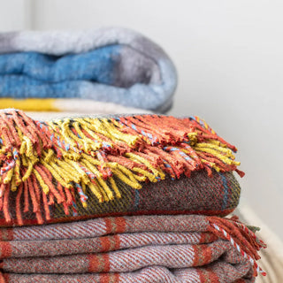 Manta riojana de lana de cuadros en tonos verde y rojo con flecos de ezcaray. Real Fábrica