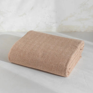 Manta de lana merino con un dibujo de espiga en color camel. Está confeccionada  a mano en Grazalema, Cádiz. Real Fábrica.