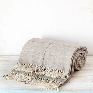 Manta maragata de líneas marrón. En la imagen se muestra doblada. Está elaborada con lana 100% pura de oveja y de gran calidad. Real Fábrica.