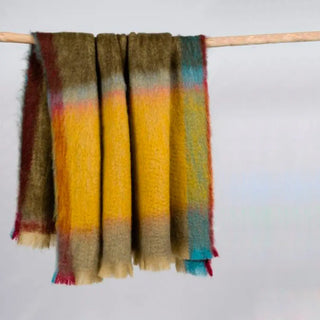 Manta de mohair de cuadros multicolor amarillo. En el primer plano se aprecia la textura de la fibra de mohair. Real Fábrica.