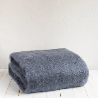 Manta de mohair en color gris azulón. En el primer plano se aprecia la textura de la fibra de mohair. Real Fábrica.