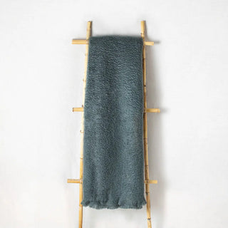 Manta mohair gris marengo, con flecos colgada sobre una escalera de madera vintage. Real Fábrica