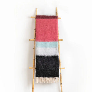 Manta mohair de ezcaray de rayas negro y buganvilla colgada de una escalera vintage. Real Fábrica.
