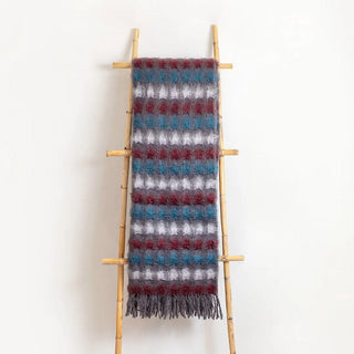 Esta manta riojana de mezcla de mohair y lana ha sido confeccionada artesanalmente, con un diseño de círculos. Equilibrio perfecto entre suavidad y resistencia térmica. Real Fábrica.