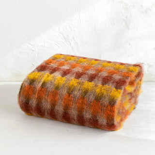 La manta riojana, elaborada a mano con una mezcla de mohair y lana, destaca por su intrincado diseño de círculos, lo que demuestra un trabajo minucioso en cada detalle y una textura suave que proporciona calidez sin exceso de peso. Real Fábrica.