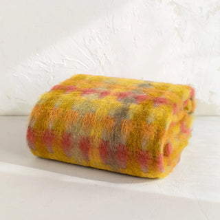 La manta riojana, elaborada a mano con una mezcla de mohair y lana, destaca por su intrincado diseño de círculos, lo que demuestra un trabajo minucioso en cada detalle y una textura suave que proporciona calidez sin exceso de peso. Real Fábrica.