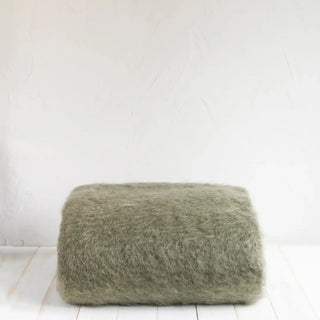 Manta de mohair de color verde oscuro. Está hecho a mano por los artesanos riojanos de Ezcaray. Real Fábrica. Real Fábrica.