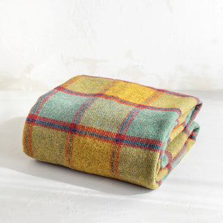 La manta riojana, elaborada a mano con una mezcla de mohair y lana, destaca por su intrincado diseño de círculos, lo que demuestra un trabajo minucioso en cada detalle y una textura suave que proporciona calidez sin exceso de peso. Real Fábrica.