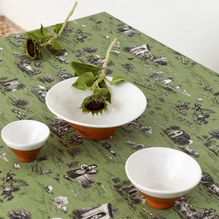 Mesa puesta con el mantel de la colección Quijote en color verde con Boles blancos y girasoles. Real Fábrica