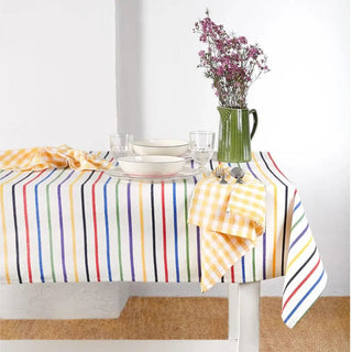 Mantel de rayas canario con vajilla y un jarrón verde con flores, ideal para una mesa fresca y natural. Real Fábrica.