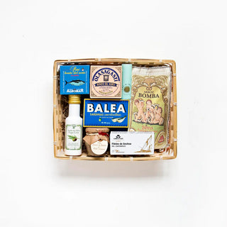 Pack España en Lata de Real Fábrica. Incluye: Paté Bonito del Norte, Bonito del Norte Vasco, Sal de Ibiza mini, Aceite Oliva Ajo, Sardinillas Aceite Oliva Balea, Arroz Albufera, Paté ibérico de Bellota, Anchoas del Cantábrico y Bandeja Grande. Foto vista desde arriba de todos los productos dentro de la cesta.