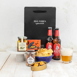 Pack gourmet Piscolabis de Real Fábrica Española. Bodegón de productos sobre fondo blanco, incluye Aceituna Gordal Deshuesada con Aceite de Oliva Ahumado y Finas Hierbas 130 g
Mejillones de las Rías Gallegas 14/18
Cocktail Premium - Tostado Con Sal 90 g
2 x Cervezas Artesanales Madrí 33 cl
Bolsa-Caja Gourmet