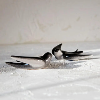 Foto de dos golondrinas manises de la fábrica de cerámica valenciana, en la foto se puede apreciar sus dos colores, negro por arriba y blanco por debajo. Real Fábrica.