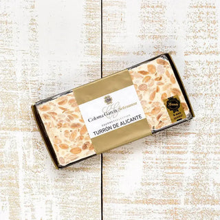 Foto cenital de un turrón artesanal de alicante sobre una mesa de madera. Real Fábrica.