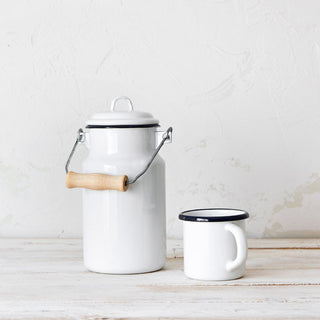 Lechera blanca de acero esmaltado junto a taza a juego