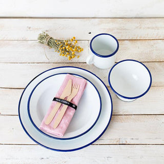 Plato de postre de peltre esmaltado blanco en mesa con vajilla